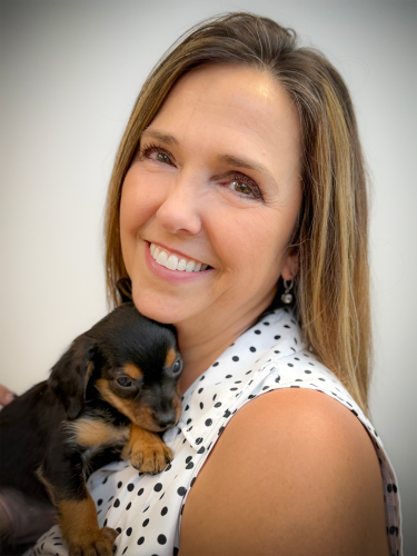 Photo of Board Member Cindy Dutra holding a puppy